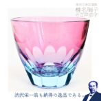 グラスにお酒を入れるとグラス底面に彫刻した模様が側面に映り込み桜の景色が広がる、砂切子ならではの不思議なグラスです! ライトブルーの素地に金赤と呼ばれるピンク色の硝子を被せた2重構造の被せ硝子を使用し、桜が咲き誇る様子を表現しています。 金赤という色味で還暦の方にもピッタリです!