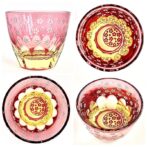 お酒を入れるとグラスの中で桜と月が広がります。 グラスにお酒を入れるとグラス底面に彫刻した模様が側面に映り込み赤く月夜の桜が広がる、砂切子ならではの不思議なグラスです。 蛍光イエローの素地に鮮やかな金赤を被せた2重構造の被せ硝子を使用し、月の輝く夜に咲く桜を表現、お酒を注ぐと月と桜が側面に映り込みます。