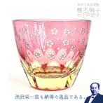 お酒を入れるとグラスの中で桜と月が広がります。 グラスにお酒を入れるとグラス底面に彫刻した模様が側面に映り込み赤く月夜の桜が広がる、砂切子ならではの不思議なグラスです。 蛍光イエローの素地に鮮やかな金赤を被せた2重構造の被せ硝子を使用し、月の輝く夜に咲く桜を表現、お酒を注ぐと月と桜が側面に映り込みます。