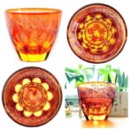 グラスにお酒を入れるとグラス底面に彫刻した模様が側面に映り込み赤く染まる紅葉が広がる、砂切子ならではの不思議なグラスです。 オレンジの素地に鮮やかな金赤を被せた2重構造の被せ硝子を使用し、側面では赤く染まった紅葉が最後の輝きを見せ、お酒を注ぐと底面の紅葉が側面に映り込み紅葉が舞い落ちる様子を表現しています。