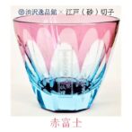 江戸砂切子　北斎 赤富士 小さいサイズですが底面の富嶽三十六景の赤富士がお酒を注ぐと綺麗に色付き正に夕日がさしている様な情景をグラスの中に見る事ができます。 ライトブルーの素地に金赤と呼ばれるピンク色の硝子を被せた2重構造の「色被せ硝子」の特注品を使用しています。金赤という色味で還暦の方にもピッタリです！