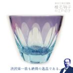 グラスにお酒を入れるとグラス底面に彫刻した模様が側面に映り込み藤が広がります。まるで藤棚の中にいる様な気持ちになれる砂切子ならではの不思議なグラスです。 赤系の色に見えるかもしれませんが、実際は「紫」。金紫という色です。ライトブルーの素地に紫色を被せた2重構造の被せ硝子を使用し、満開の藤を表現した至高の一品です。