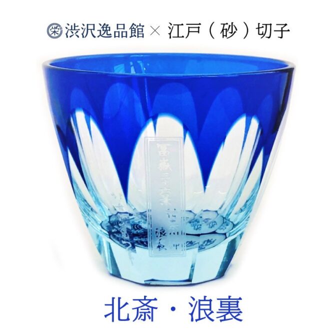 人気の北斎シリーズのぐい呑み。小さいサイズなのに底面の浪裏がお酒を注ぐとあらあらしさを増し迫力のある情景をグラスの中に見る事ができます。 素材はライトブルーの素地に瑠璃色のガラスを被せてあるガラスを使用。 江戸切子でよく使われる「色被せ硝子」の特注品です。