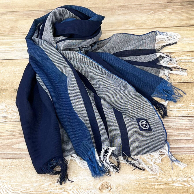 江戸の中期より織られておりました和田縞紬を再現した、セルヴィッチ生地（旧式織機を使って織られた生地）の薄手で柔らかな藍染のストール。手染めされた藍染の繊維をモダンなストライプに織り上げています。 春、夏、秋とフル活用でき、和洋どんなファッションにも合わせられるストールです。